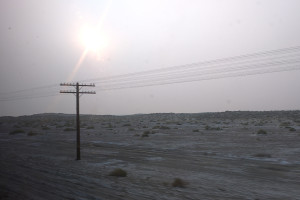 Desert landscape with one telephone pole and grey sky from wildfires.