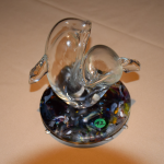 Small blown glass sculpture of two dolphins on cast glass base.