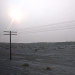 Desert landscape with one telephone pole and grey sky from wildfires.