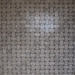 Small white marble tiles with grey veins in basketweave pattern