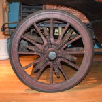 Twelve spoke wooden wheel suspended on six coil springs.