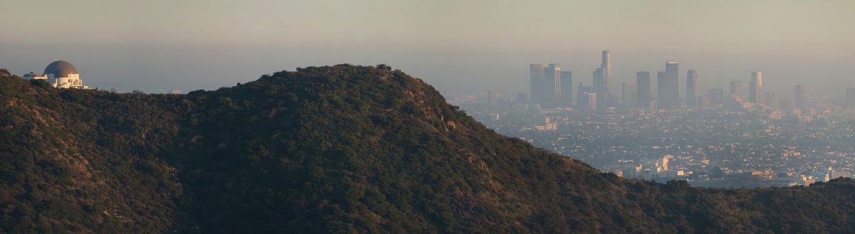 Panoramic photo of a smoggy day in LA including the Griffith Park Observatory and the downtown skyline